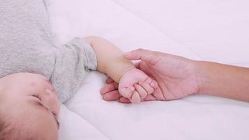 Close up of Mother holding hands her newborn baby. Happy kid, cute family. Mother love and fidelity. video