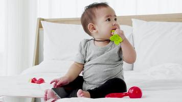 Joyful baby girl paying with toy on the bed video