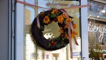 Beautiful decorative wreath of dried plants and flowers hanging on the door, isolated close-up photo