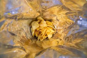 close-up view inside of a big silver bag of potato chips with selective focus photo