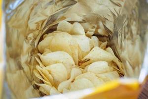 Potato chips in open snack bag close up photo