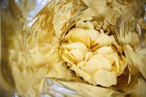 Potato chips in open snack bag close up photo