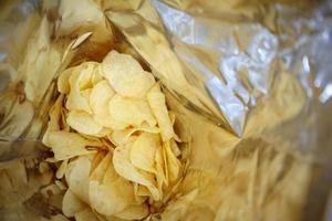 Potato chips in open snack bag close up photo