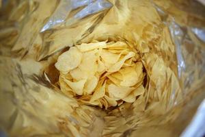 Potato chips in open snack bag close up photo