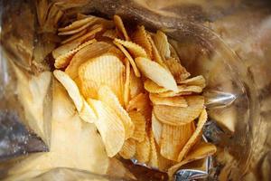 Potato chips in open snack bag close up photo