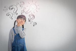 Happy asian school kid thinking photo