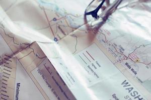 Map, map of Washington state, pen, glasses, cell phone, coffee cup on the table. photo