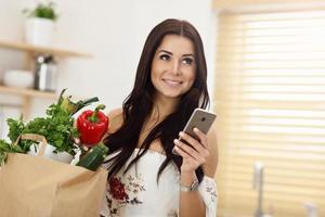 Portrait of smiling young housewife in modern kitchen photo