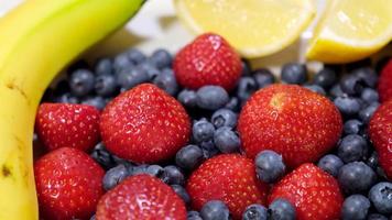 Fruit salad. Assorted fruits. Fresh strawberries, blueberries, banana, lemon. Tropical healthy vitamin mix video