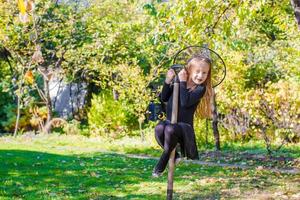 Adorable little girl in Halloween which costume having fun outdoors photo