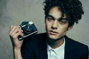 handsome guy in a suit with a camera lessons curly hair emotions model photo