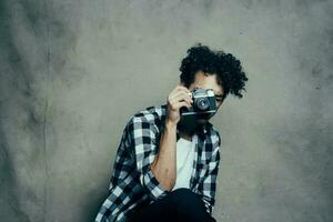 handsome male model in a shirt and a t-shirt on a gray background curly hair hairstyle camera Studio photo