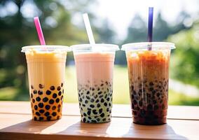 illustration of product photo of 3 plastic cups of boba milk tea, with bubbles, fun, blurry outdoor and nature background