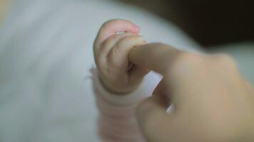 Baby daughter holding mum finger video