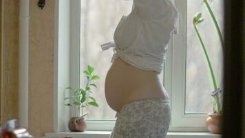 Happy pregnant woman dancing to music on mobile video