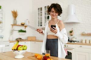 young pretty woman cooking at home, morning kitchen, healthy food photo