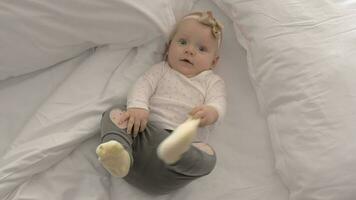 Pretty blue-eyed baby girl with bow on bed video