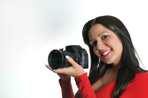 Young woman holding camera in hand taking picture isolated photo