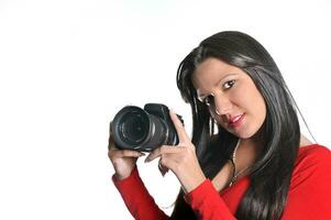 Young woman holding camera in hand taking picture isolated photo