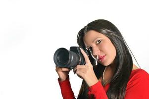 Young woman holding camera in hand taking picture isolated photo