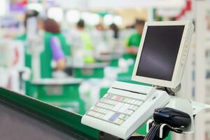 Empty cashier checkout desk with terminal in supermarket photo