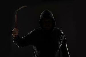 Criminal in dark clothes and balaclava with scythe photo