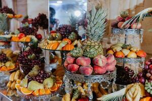 Wedding decorations. Reception. Buffet. Fruits and cheese on plates with bread in boxes. Food bar decorated by flowers and lanters photo