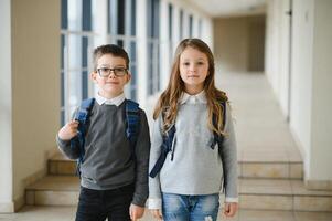 Happy school kids in corridor at school. Learning concept. photo