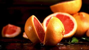 Super slow motion grapefruit falls on the table and splits into two halves. Filmed at 1000 fps.On a black background. video