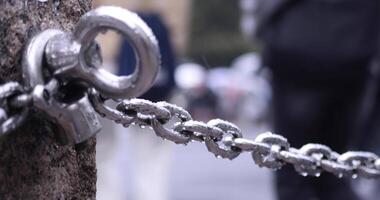 A silver chain behind walking people at the SHIBUYA crossing rainy day video