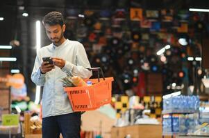 portrait of indian male in grocery with positive attitude photo