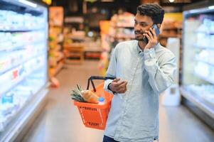 portrait of indian male in grocery with positive attitude photo