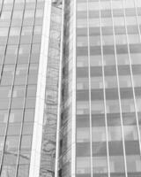 Fragment of a modern office building. Abstract geometric background. Part of a skyscraper with glass windows. Black and white. photo