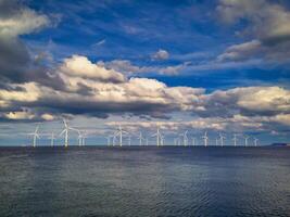 Offshore Wind Turbine in a Windfarm under construction off the England Coast at sunset photo