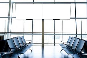 Departure lounge at the airport with seats in a row with TV photo