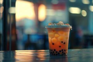 Cold bubble tea with tapioca pearls is sitting on table in cafe photo