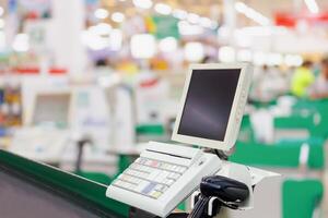 Empty cashier checkout desk with terminal in supermarket photo