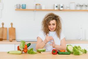 Happy young housewife mixing vegetable salad photo