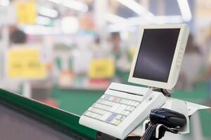 Empty cashier checkout desk with terminal in supermarket photo