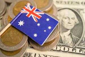 Stack of coins with Australia flag and US dollar banknotes. photo