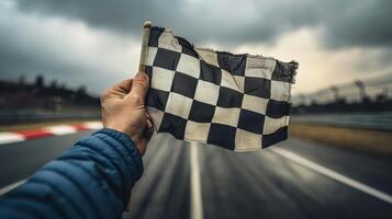 Extreme closeup of a hand gripping the checkered flag emphasizing the intense focus and determination of the person holding onto this timeless symbol of victory photo