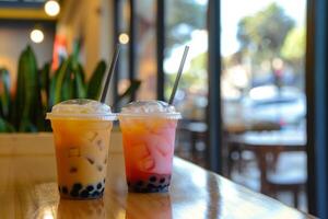 Two iced bubble tea drinks sitting on cafe countertop photo