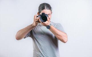 Portrait of handsome photographer taking photos at you isolated. Male photographer taking photos isolated