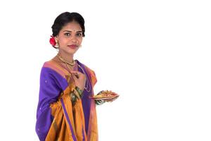 Indian woman performing worship, portrait of a beautiful young lady with pooja thali isolated on white background photo