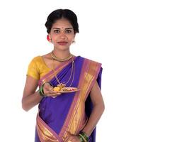 Indian woman performing worship, portrait of a beautiful young lady with pooja thali isolated on white background photo