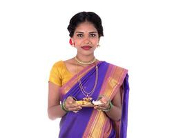 Indian woman performing worship, portrait of a beautiful young lady with pooja thali isolated on white background photo