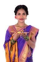 Indian woman performing worship, portrait of a beautiful young lady with pooja thali isolated on white background photo