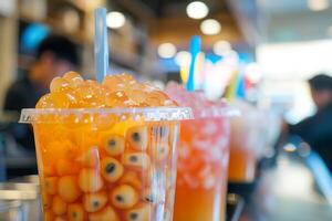 Plastic cup filled with passion fruit bubble tea and tapioca pearls is displayed on a counter photo