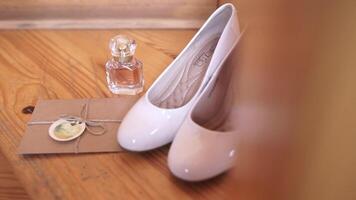 A stylish pair of white shoes and elegant perfume grace a wooden table video