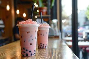 Two iced bubble tea drinks sitting on a cafe countertop photo